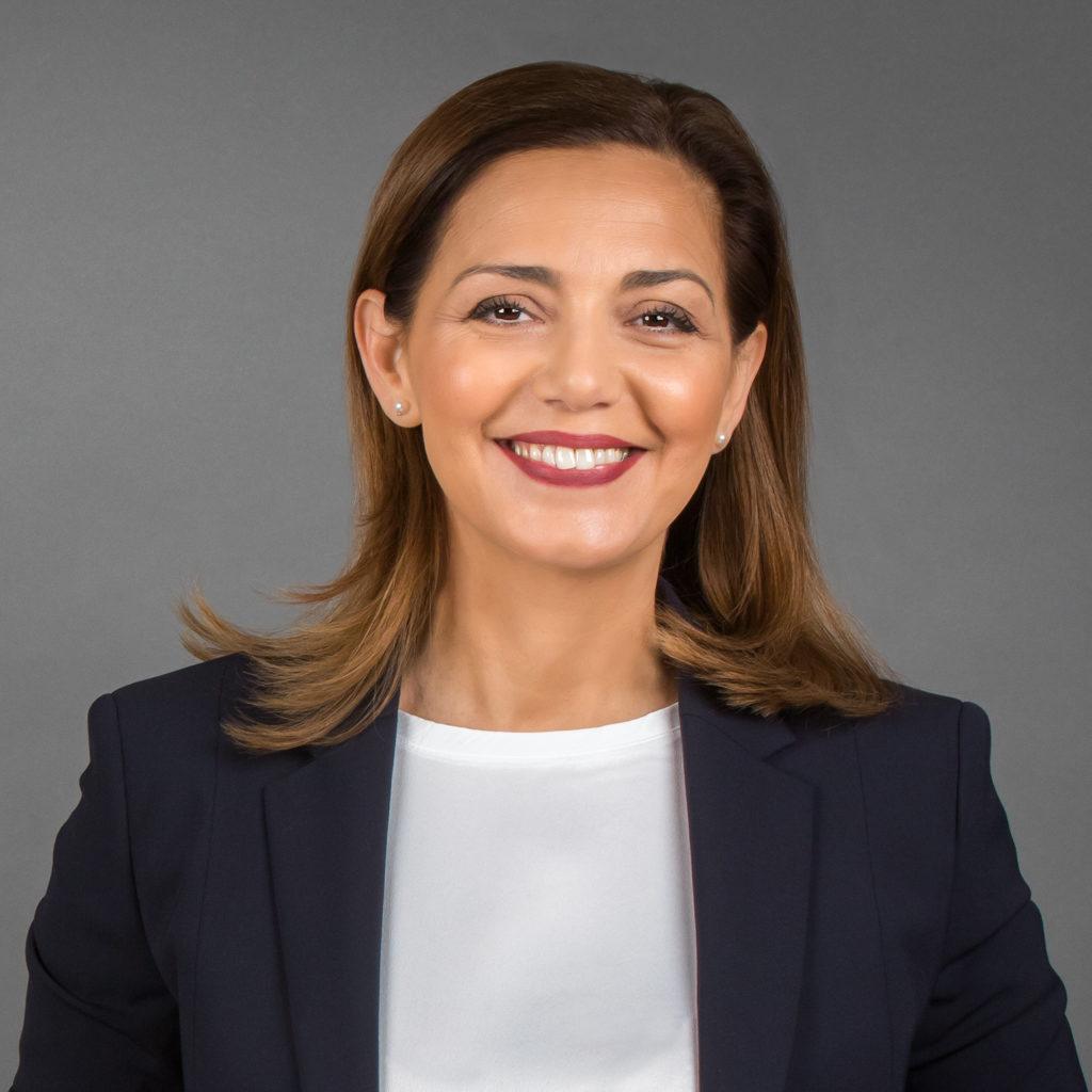 Porträt einer lächelnden Geschäftsfrau vor einem grauen Hintergrund