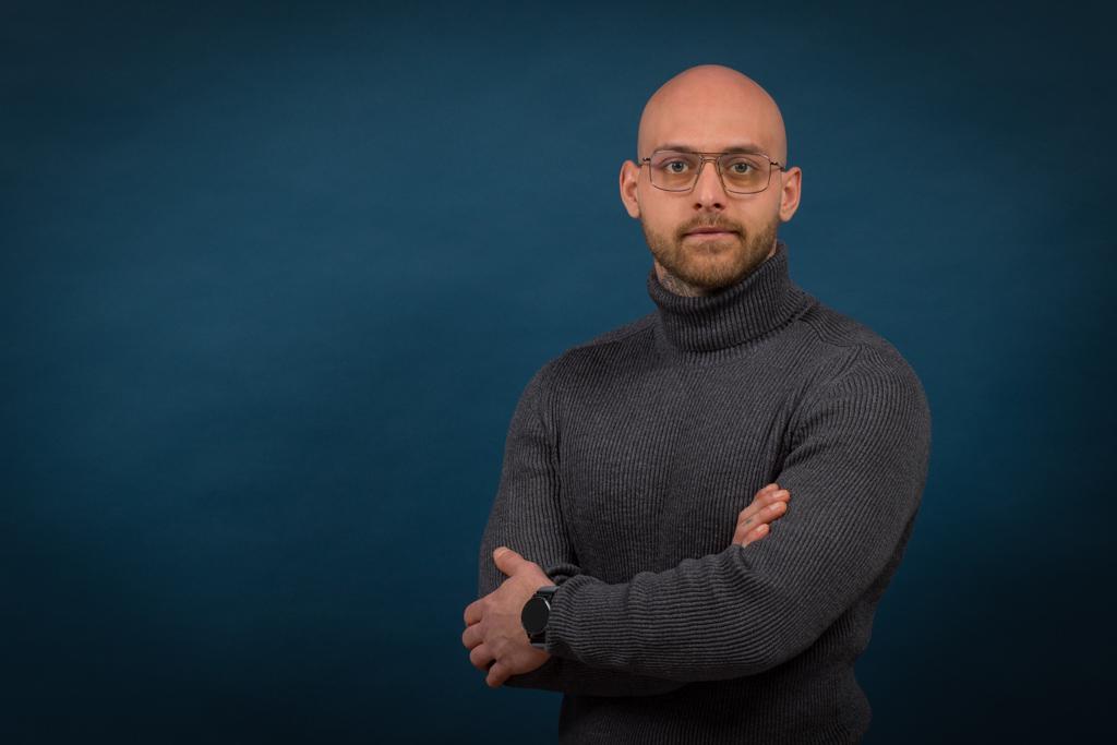 Business - Porträt eines jungen Mannes mit verschränkten Armen und blauem Hintergrund - Fotostudio Hanau